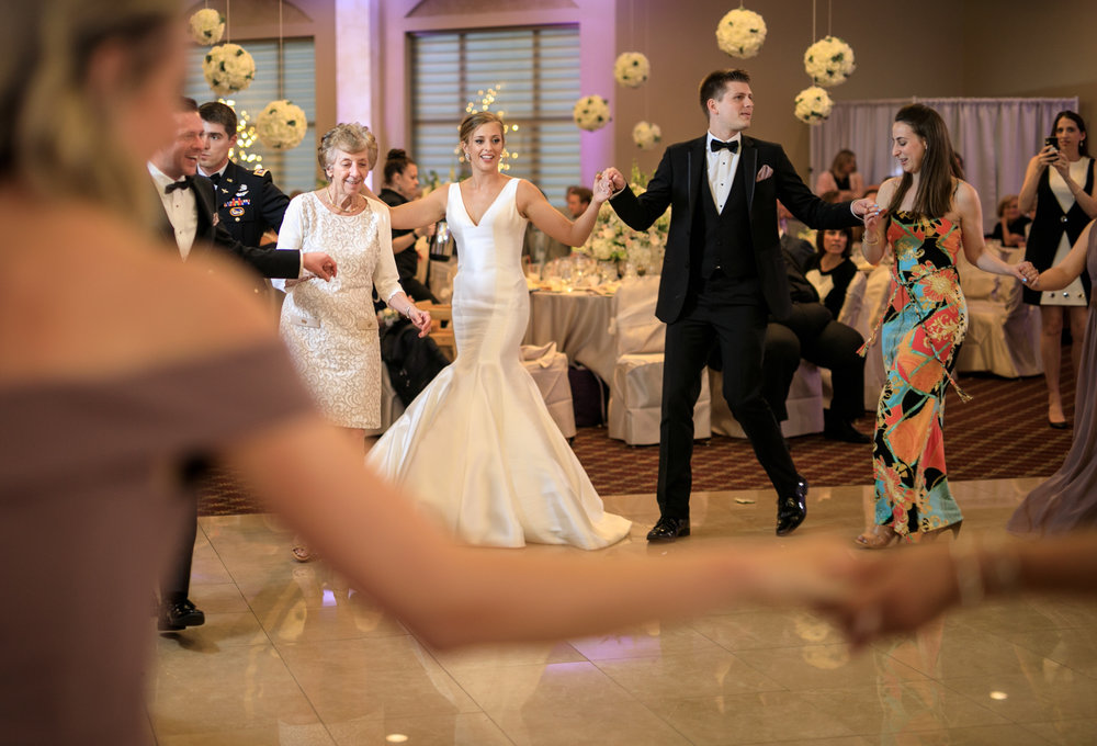 Bride and groom greek dancing at wedding