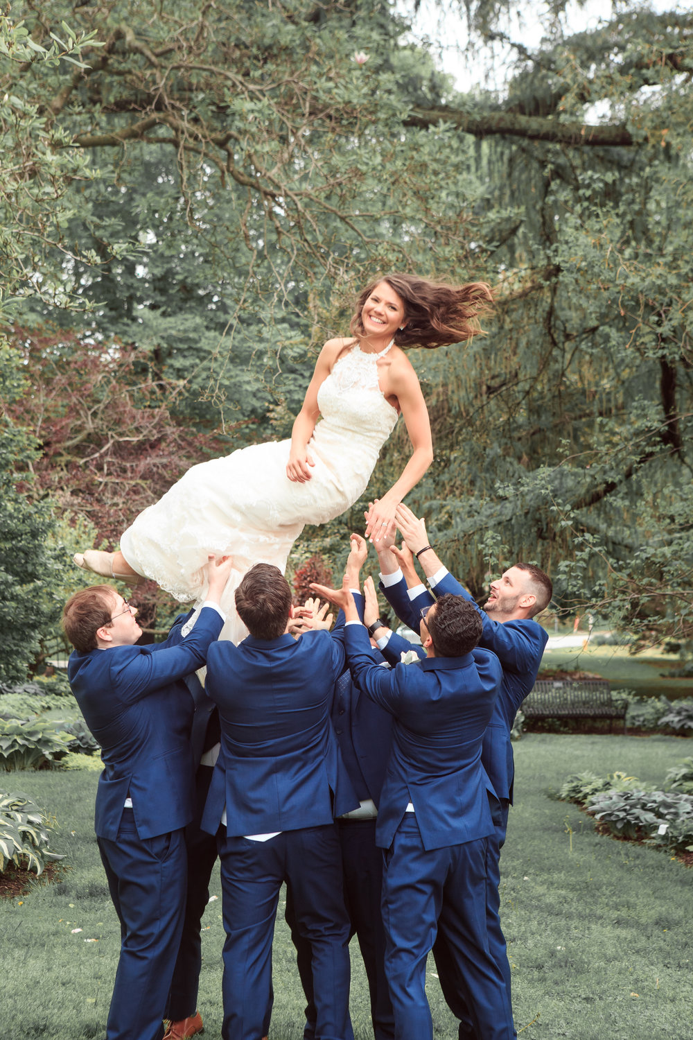 Throwing-bride-in-the-air-fun-wedding-pose-wih-groomsmen-with-bride.jpg