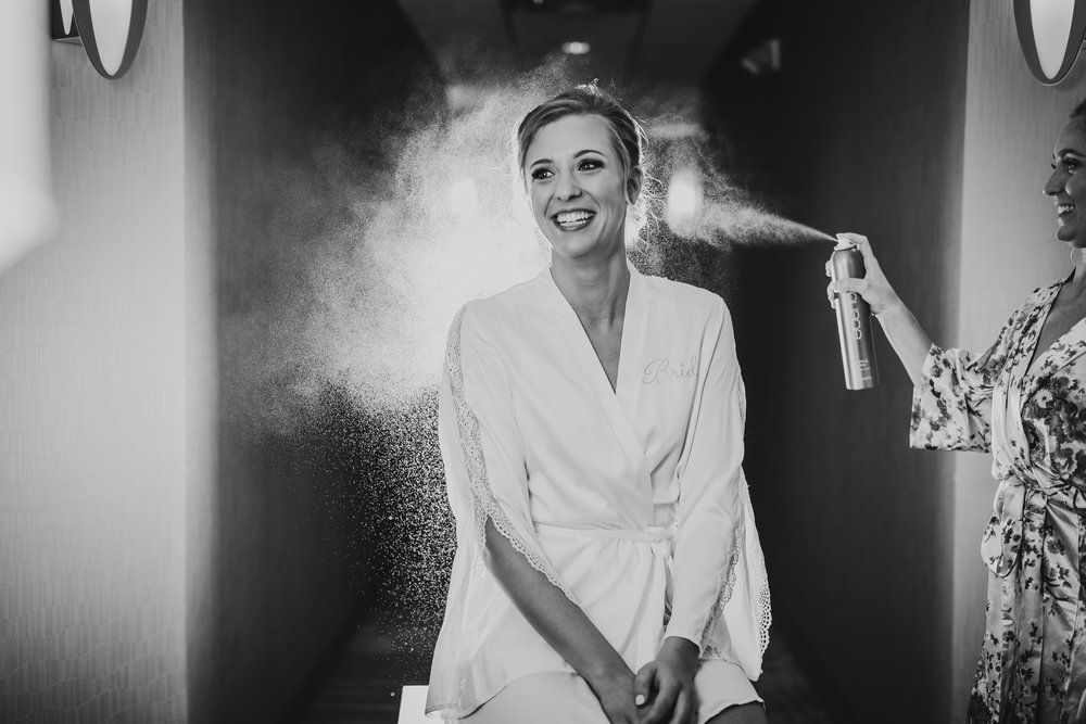 bride getting ready in hotel lauren ashley studios hair spray photo