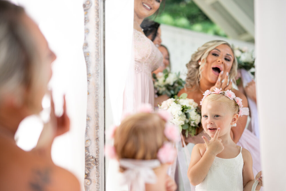 bride and flower girl get ready for wedding day in this adorable photograph