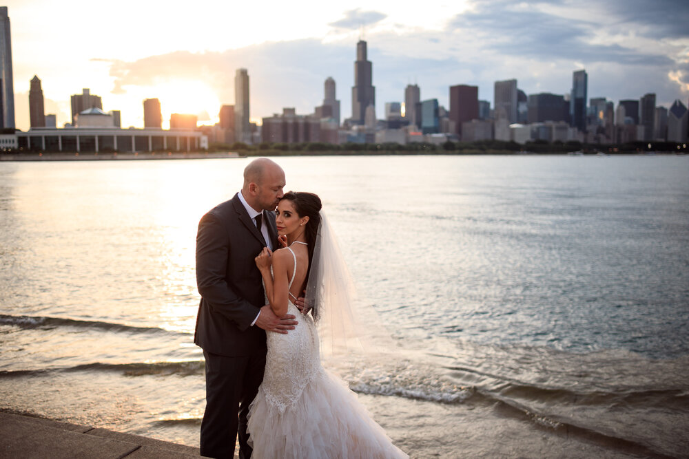 chicago police department cpd groom kisses his bride in front of a downtown chicago sunset